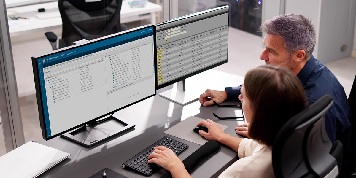Two IT professionals analyzing data and system performance on dual monitors, working on network management and business applications in an office environment